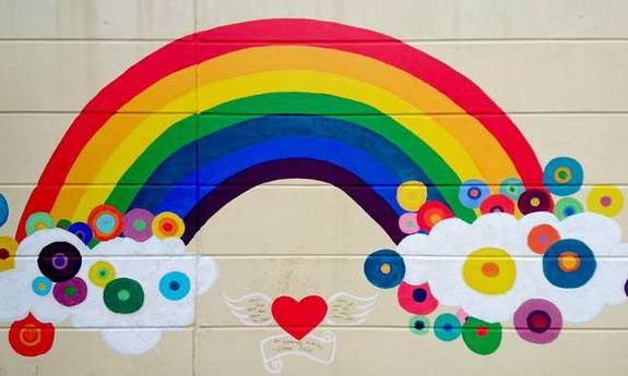 Ein von Kindern gemalter Regenbogen auf einer Mauer
