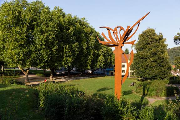 Eisengraben Quierschied im Sommer, Skulptur "Blütenanker" rechts vor Bäumen